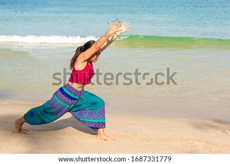 Asian Thai woman practicing yoga in Ao Thong Nai Pan Noi beach, Koh Phangan island, thailand