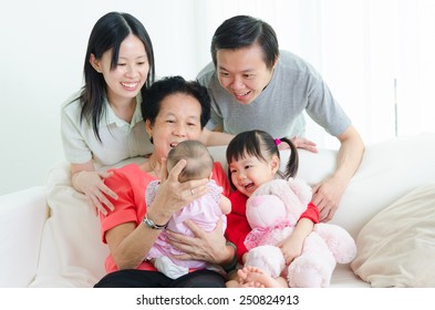 Asian Three Generations Family Looking At The New Born Baby.