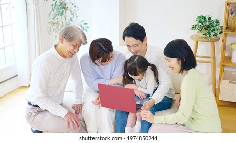 Asian Three-generation Family Watching A Laptop Pc. Online Education. E-learning.