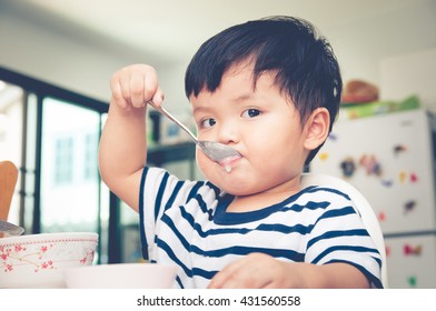 Asian Toddler Boy Eating On High Chair