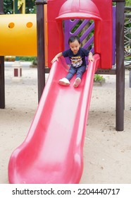 Asian Toddler Boy Enjoy Playing In Playground , Kid Having Fun