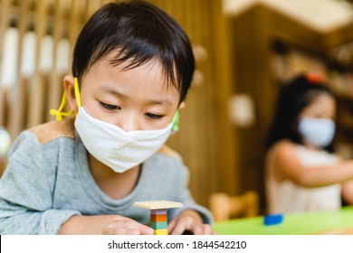 Asian Toddler Boy Playing Toy Block In Day Care School.3.5 Years Old Boy Child Wearing Face Mask In Day Care.Covid-19 Coronavirus.Nursery.Social Distancing In School Kid.Back To School.New Normal.