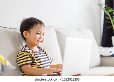 Asian Toddler Boy Student Online Learning Class Study Online Video Call Zoom Teacher, Happy Boy Learn Science Online With Laptop At Home.New Normal.Covid-19 Coronavirus.Social Distancing.stay Home.