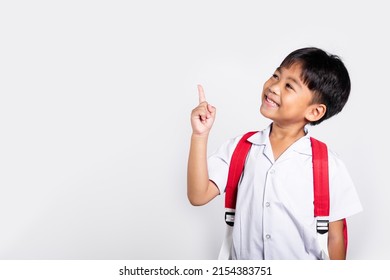 Asian toddler smiling happy wear student thai uniform red pants keeps pointing finger at copy space in studio shot isolated on white background, Portrait little children boy preschool, Back to school - Shutterstock ID 2154383751