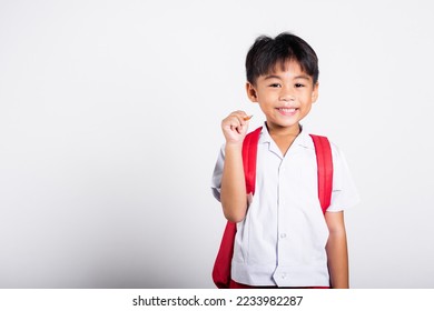 Asian toddler smiling happy wear student thai uniform red pants holding pencil for writers notebook in studio shot isolated on white background, Portrait little children boy preschool, Back to school - Powered by Shutterstock
