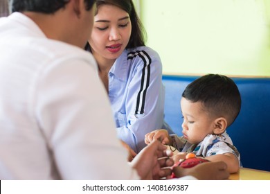 Asian Todler Eating Sweet Cake With His Family At Cafe In The Morning