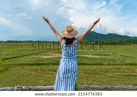 Asian tourists, backpacking, traveling, raising their hands, free life, looking at the mountains and rice fields