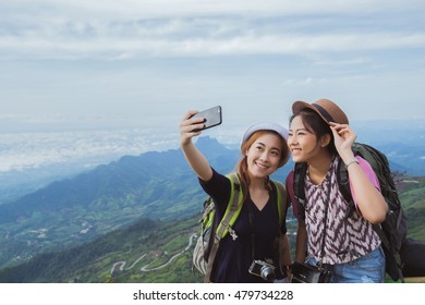 Asian tourists are enjoying the selfie with friends. They have come to the mountains of Phu Tubberk