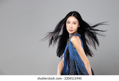 Asian Transgender Woman With Long Black Straight Hair, Wind Blow Throw In The Air. Female Spin Turn Around And Wear Blue Fashion Sensual Sexy Dress, Gray Background Isolated Copy Space