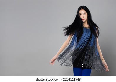 Asian Transgender Woman With Long Black Straight Hair, Wind Blow Throw In The Air. Female Spin Turn Around And Wear Blue Fashion Sensual Sexy Dress, Gray Background Isolated Copy Space