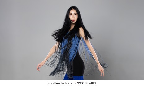 Asian Transgender Woman With Long Black Straight Hair, Wind Blow Throw In The Air. Female Spin Turn Around And Wear Blue Fashion Sensual Sexy Dress, Gray Background Isolated Copy Space