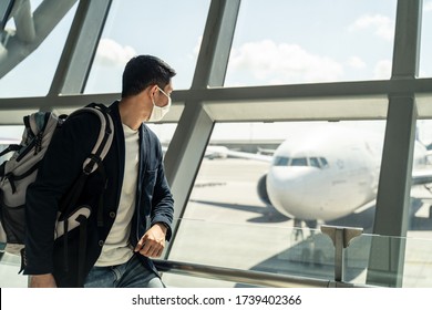 Asian traveler business man wearing face mask waiting to board into airplane, standing in departure terminal in airport. Male passenger traveling by plane transportation during covid19 virus pandemic. - Shutterstock ID 1739402366