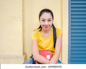 Asian traveler woman sitting on the corner of Bangkok old town street.