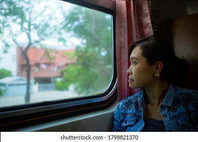 Asian traveller looking over veiw near the window.Enjoy and happy in vintage train in Thailand.Adventure lifestyle people. Malaysian sitting on the seat. - Shutterstock ID 1798821370