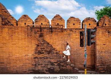 Asian traveller woman walking on the street of Chiang mai old wall in Chiangmai city, Thailand