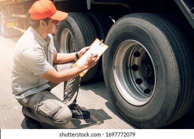 Asian Truck Driver Holding Clipboard Inspecting Safety Check A Truck Tire, Vehicle Maintenance Checklist A Semi Truck