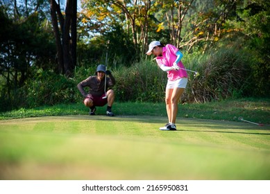 Asian Two Approach On The Tee Off For Swing And Hitting Golf Ball And Looking Fairway In Course. 