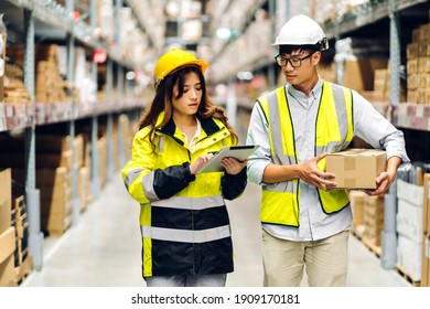 Asian two engineer in helmets team order details on tablet computer for checking goods and supplies on shelves with goods background in warehouse.logistic and business export - Powered by Shutterstock