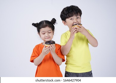 Asian Two Kid Couple Boy And Girl Happy Eating Donut Cake With Chocolate Flavor, Isolated On White Background