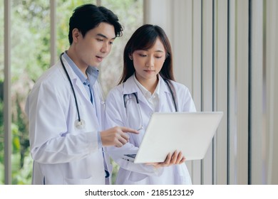 Asian two male female professional doctor using computer laptop checking patient's medical records ,Portrait doctor healthcare professionals - Powered by Shutterstock