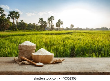 Asian uncooked white rice with the rice field background - Shutterstock ID 440302306