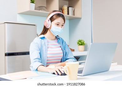 Asian University Female Student Wearing Face Mask Is Learning And Looking Online Course Through Laptop At Home