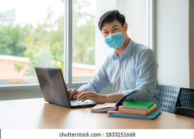 Asian University Student Boy Wearing Face Protective Medical Mask For Protection From Virus Disease Working With Laptop At College. Education, High School, University, Learning And People Concept 