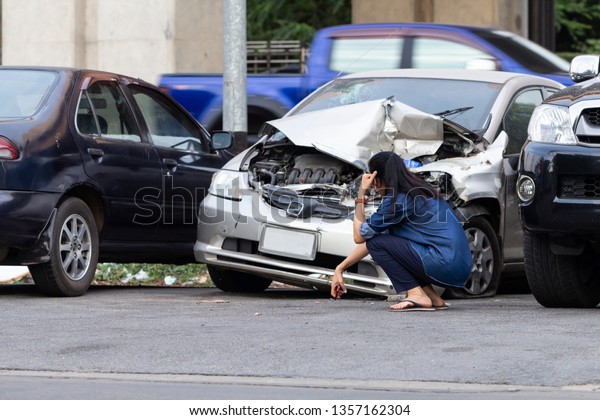 街道での自動車衝突事故の前にいるアジア人の運転手の女性が動揺した の写真素材 今すぐ編集