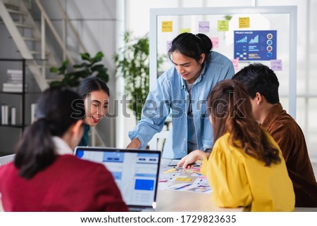 asian ux developer and ui designer brainstorming about mobile app interface wireframe design on meeting table with at modern office.Creative digital development agency