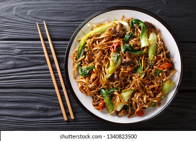 Asian vegetarian food udon noodles with baby bok choy, shiitake mushrooms, sesame and pepper close-up on a plate on the table. horizontal top view from above
 - Powered by Shutterstock