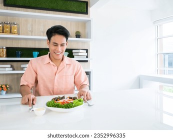 Asian vegetarian man ready to eat breakfast refreshing salad organic dish for healthy lifestyle and get more nutrition on white kitchen bar in the morning before go to work at the startup building - Powered by Shutterstock