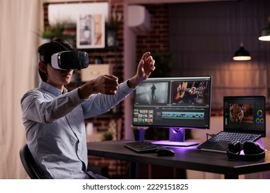 Asian videographer working on media production with vr headset and creative software, editing movie footage or film montage on computer. Creating video edit with audio and visual effects on monitor. - Shutterstock ID 2229151825