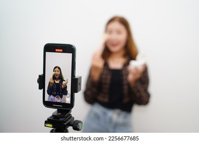 Asian vlogger female influencer shows how to make up live on IG story reel tiktok at home studio. Gen Z people film selfie shooting app viral videos.