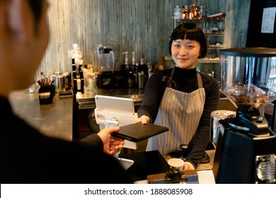 Asian Waitress Giving Bill To Customer After He Finished Food.