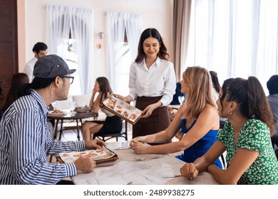 Asian waitress serving food to group of diverse customer in restaurant. Attractive female server service woman work by deliver meal and drink to consumer at their table in dining room with happiness. - Powered by Shutterstock