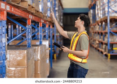 Asian warehouse worker inspect box of products on warehouse shelves - Powered by Shutterstock