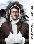 Asian winter sport fashion man in snow mountain landscape. Wearing brown jacket and fur hoody and white gloves.