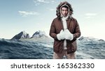 Asian winter sport fashion man in arctic mountain landscape. Wearing brown jacket with fur hoody and white gloves.