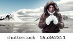 Asian winter sport fashion man with backpack in snow mountain landscape. Wearing brown jacket with fur hoody and white gloves.