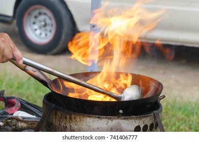 Asian Wok Cooking With Flames In An Open Style Street Food Kitchen.