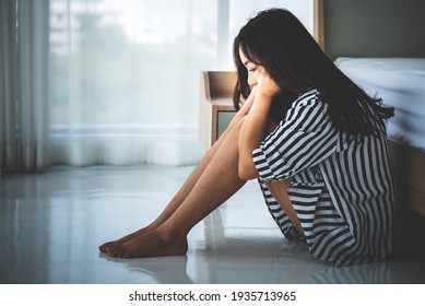 Asian woman, 23 year old, sitting near a white bed in her bedroom, She is having sadness and stress from work And health problems, to people and heartbroken concept.