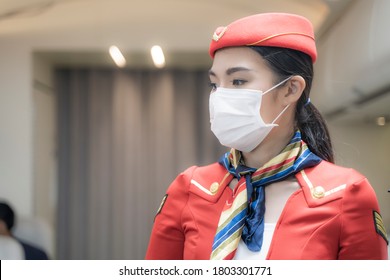 Asian Woman Air Hostess Or Flight Attendant Boarding Plane Standing In Plane. People Wearing Face Mask. Coronavirus Flu Virus Travel In Oversea Travel.