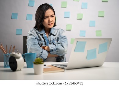 Asian Woman Angry Looking At Laptop Reading News At Home Office. WFH. Work From Home. Prevention Coronavirus COVID-19 Concept.