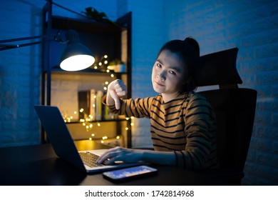 Asian woman annoyed and showing thumb down working overtime at home. WFH. Work from home for avoid the Coronavirus COVID 19 concept. - Shutterstock ID 1742814968