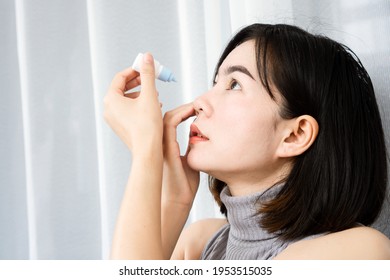 Asian Woman Applying Eye Drops To Refresh From Dry, Tired Eyes 