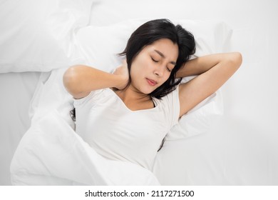 Asian Woman Around The Age Of 25 In A White T-shirt Can't Sleep Well. She Had Back Pain And Neck Pain That She Couldn't Sleep.