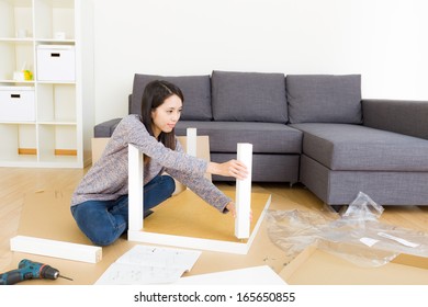 Asian Woman Assembling New Furniture 