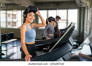 Asian woman athlete in sportswear wearing VR glasses jogging exercise on treadmill in virtual reality cyberspace at fitness gym. Metaverse digital entertainment technology for health care motivation. - Powered by Shutterstock