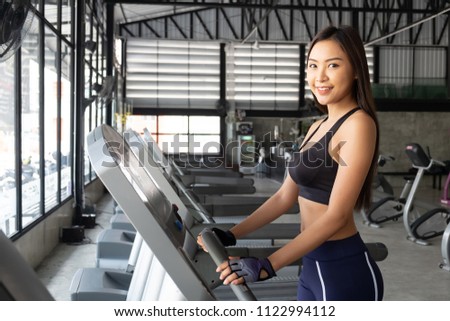 Asian woman Attractive young sports woman is working out in gym. Doing cardio training on treadmill. Running on treadmill.