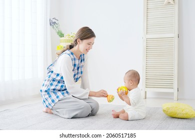 Asian Woman And Baby Playing At Home